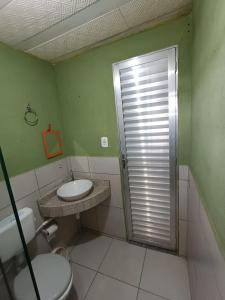 a bathroom with a toilet and a sink and a shower at Casinha Charmosa in Miguel Pereira