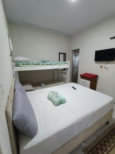 a bedroom with a white bed with a bunk bed gmaxwell gmaxwell gmaxwell at Casinha Charmosa in Miguel Pereira +12 photos
