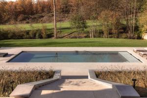 a swimming pool in the middle of a yard at Tarida Durbuy in Durbuy