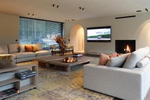a living room with a couch and a tv at Tarida Durbuy in Durbuy