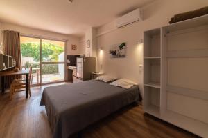 a bedroom with a bed and a desk and a window at Résidence Agathéa - Centre Port - Cap d'Agde in Cap d'Agde