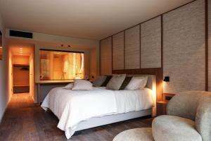 a bedroom with a large white bed and two chairs at Tarida Durbuy in Durbuy +20 photos