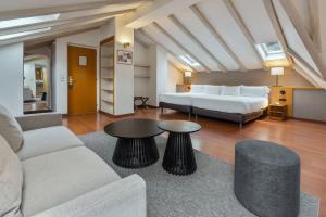 a living room with a bed and a couch and tables at Hotel de l'Isard in Andorra la Vella
