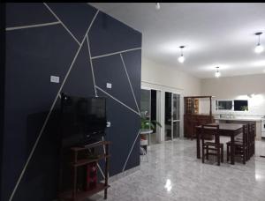 a living room with a television and a dining room at Los Horneros in Cerrillos