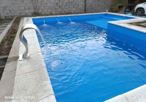 a blue swimming pool with a water fountain at Los Horneros in Cerrillos +4 photos