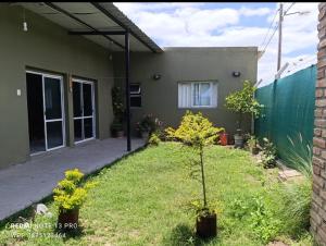 a house with a small tree in a yard at Los Horneros in Cerrillos