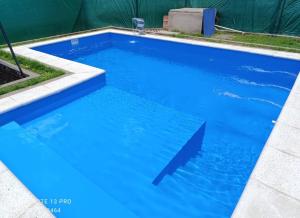 a swimming pool with blue water in a yard at Los Horneros in Cerrillos