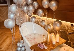 a room with balloons and a bath tub with a table at Villa La Roca Garden & Spa ADULTS ONLY in Kościelisko