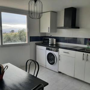 a kitchen with a washing machine and a table and a window at Apartamento Rural Borgia in Borja