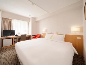 a hotel room with a large bed and a television at Hotel Sunroute Taipei in Taipei