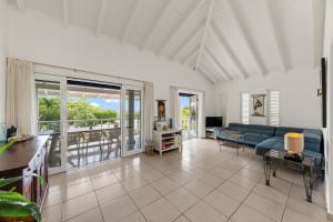 a living room with a blue couch and a balcony at Villa Brisa, Tropical Escape at Coral Estate, Curaçao in Willibrordus