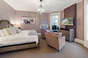 a bedroom with a bed and a chair and a television at The White Inn in Fredonia