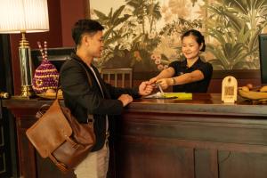a man and a woman standing at a bar at Lao Poet Hotel in Vientiane +63 photos