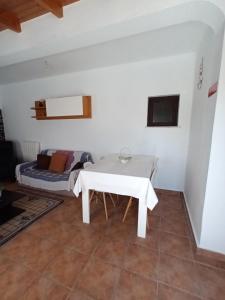a white table in a room with a couch at Casa marreiros in Aljezur