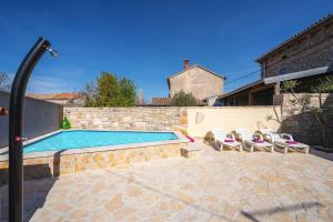 a swimming pool with lounge chairs and a house at Casa Mia By Kompas Villas in Butkovići