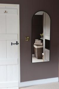 a mirror on a wall next to a door at Plum Cottage in Cottesmore +20 photos