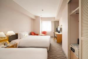 a hotel room with two beds and a desk at Hotel Sunroute Taipei in Taipei +19 photos