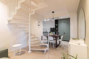 a white staircase in a living room with a table at Appartamento Di Morgana Sirmione in Sirmione