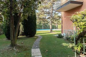a walkway in front of a house with trees at Appartamento Di Morgana Sirmione in Sirmione +27 photos