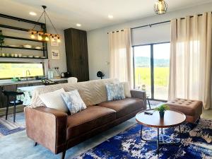 a living room with a brown couch and a table at The Zain's Pool Villa for 4 pax, Langkawi in Ulu Melaka