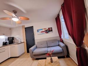 a living room with a couch and a kitchen at Le patio Mézois in Mèze
