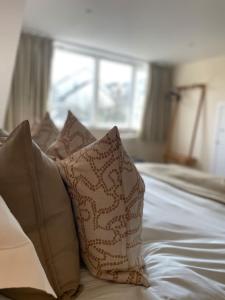 a group of pillows on a bed with a window at Martindales Yard in Kendal