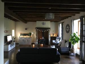 a living room with a couch and a table at Grande maison entre vert et bleu in Saint-Yrieix-la-Montagne