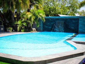 a large blue swimming pool with a fountain at Haleys Guest House in Benoni