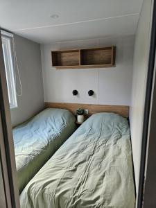 two beds in a small room with avertisement for at Eekhoorn 7 in Gasselte +11 photos