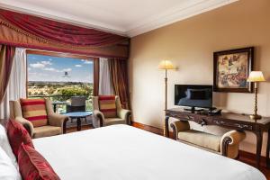 a hotel room with a bed and a window at Convento do Espinheiro, Historic Hotel & Spa in Évora