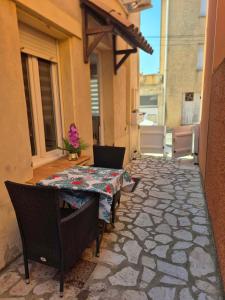 a patio with a table and chairs on a patio at Chez Isa, Les pieds dans l'eau in Valras-Plage