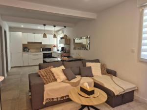 a living room with a couch and a table at Chez Isa, Les pieds dans l'eau in Valras-Plage