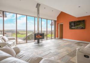 a living room with a fireplace and glass walls at Spacious Barn Conversion 4 Bedroom Hot Tub - Pass the Keys in Seathwaite