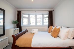 a bedroom with a large bed with a window at Spacious 4Bed Home with Decked Garden Forest Hill - Pass the Keys in London