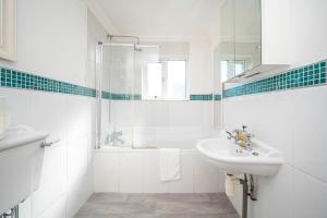 a white bathroom with a sink and a shower at Spacious 4Bed Home with Decked Garden Forest Hill - Pass the Keys in London +55 photos