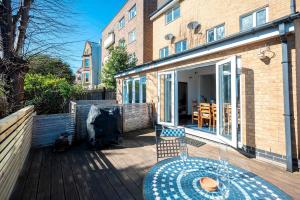 a patio with a table and chairs on a deck at Spacious 4Bed Home with Decked Garden Forest Hill - Pass the Keys in London