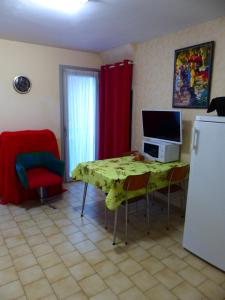 a kitchen with a table with a television and a refrigerator at Pied A Terre in Amélie-les-Bains-Palalda