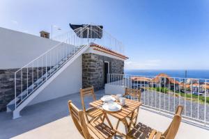 a view from the balcony of a villa with a table and chairs at Social Lodge Galinho House - Sea View - Calheta in Estreito da Calheta