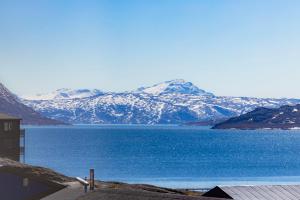 a view of a large body of water with snow covered mountains at Hotel Aurora in Nuuk