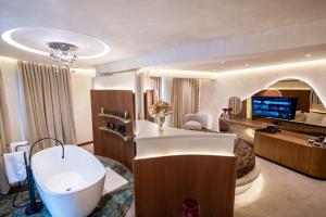 a bathroom with a bath tub and a bedroom at Mattis Hotel in Tirana +134 photos