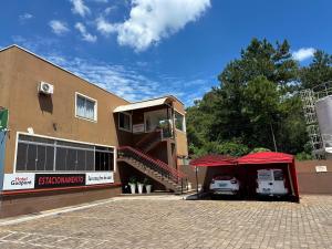a building with a red tent next to a building with a stairway at Hotel Guaporé - Campo Bom RS in Campo Bom