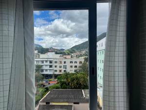 a view of a city from a window at Apartamento alto de Teresópolis in Teresópolis