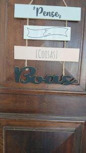 a wooden drawer with three signs on top of it at Aconchego - Centro in Miguel Pereira