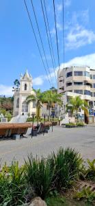 a building with a clock tower and a church at Aconchego - Centro in Miguel Pereira