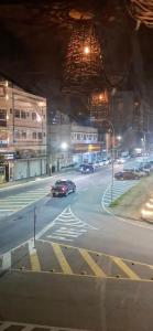 a car driving down a city street at night at Aconchego - Centro in Miguel Pereira