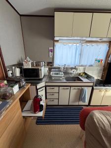 a small kitchen with a sink and a microwave at Hermit 知床 in Shari