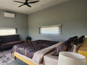 a bedroom with a bed and a ceiling fan at The Zain's Pool Villa for 4 pax, Langkawi in Ulu Melaka +15 photos