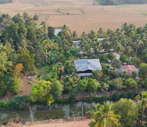 an aerial view of a resort with trees and a river at Hestia Homestay- 2 Bedroom Retreat Aymanam in Kottayam