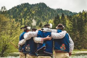 a group of men standing around a river at Chata Pieniny in Lesnica
