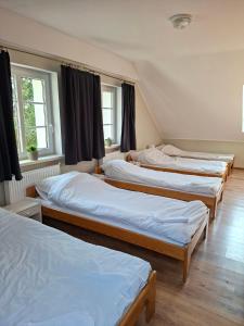 a group of four beds in a room at Dom w Puszczy Noteckiej in Mierzyn +29 photos